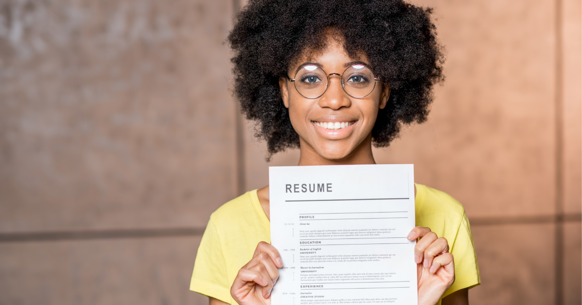 A recent college graduate holds up her resume and smiles as she begins her job search